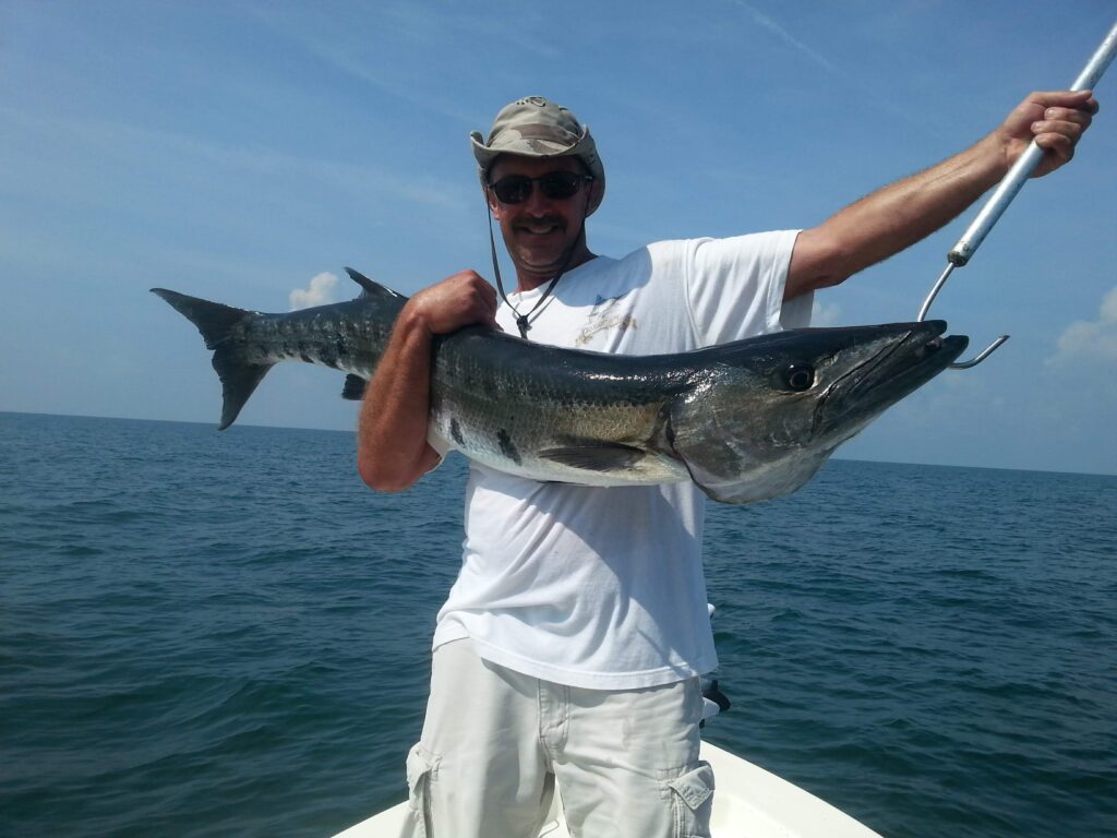 Angler holding a large king mackerel caught offshore in the Gulf of Mexico on a Sarasota fishing charter