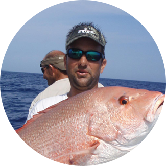 Captain Eric Paquin holding a red snapper caught on an offshore fishing charter out of Sarasota, FL